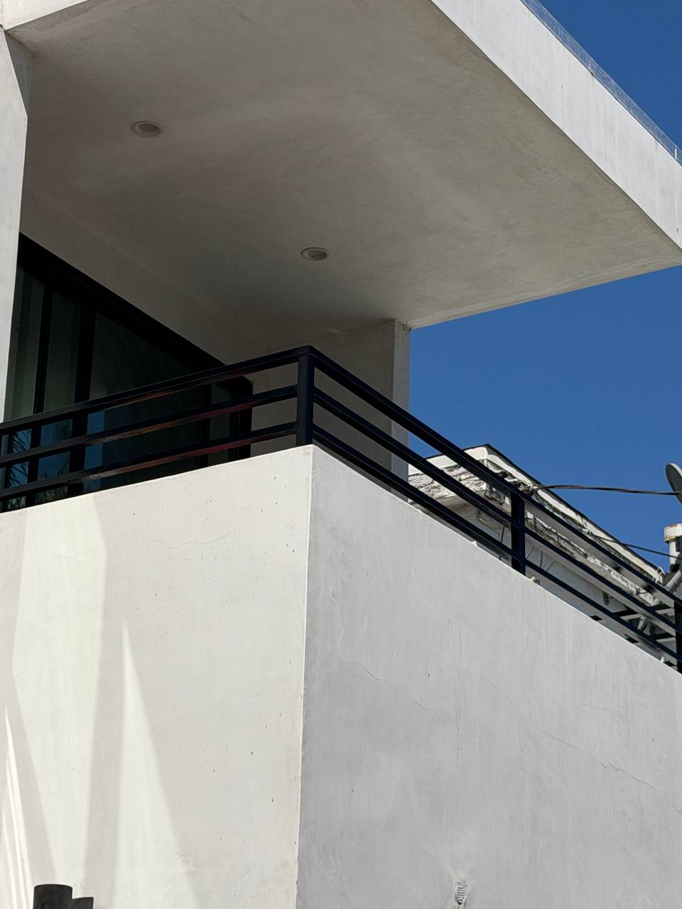 Corner detail of restored balcony railing with glossy black finish in Venice Beach